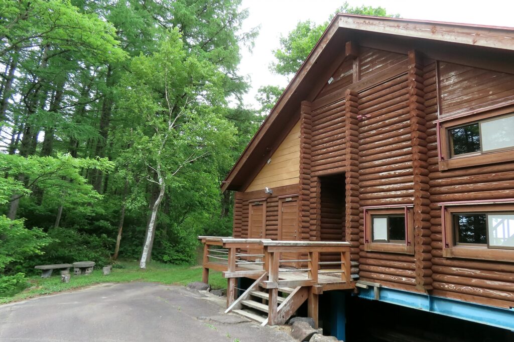 自然豊かな森の中に佇む本格的な大型ログハウス(コテージ)の外観