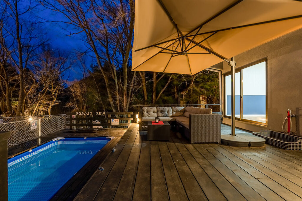客室専用のプライベートプールとソファを備えたラグジュアリーなグランピングのウッドデッキ