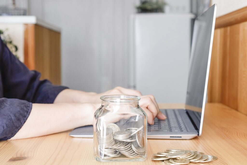 パソコンで株式投資や資産管理を行う様子と貯蓄のイメージ