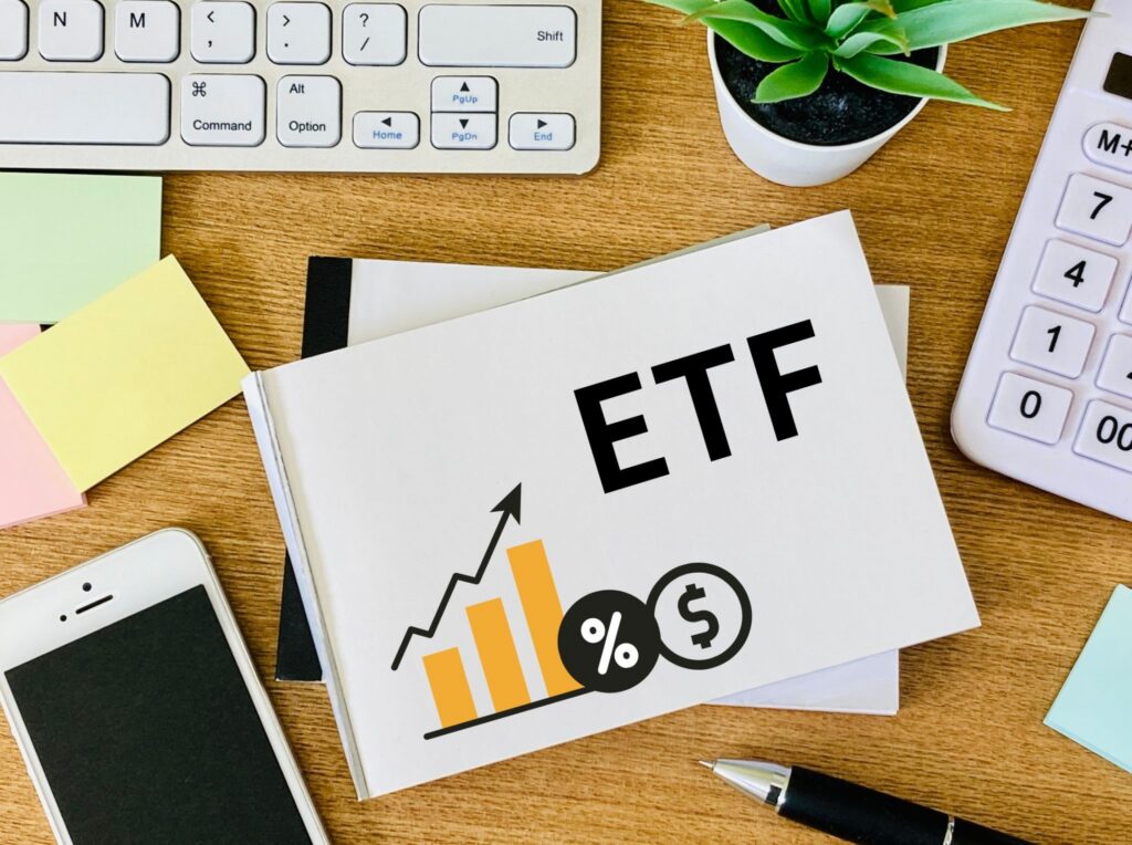 デスク上の電卓と「ETF」と大きく書かれたノート