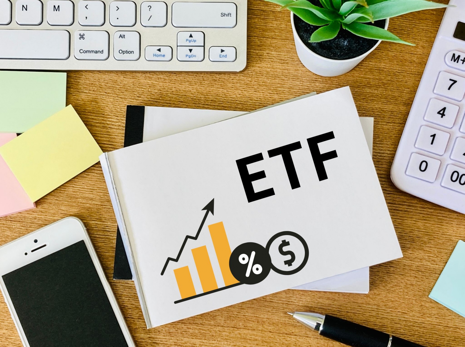 デスク上の電卓と「ETF」と大きく書かれたノート