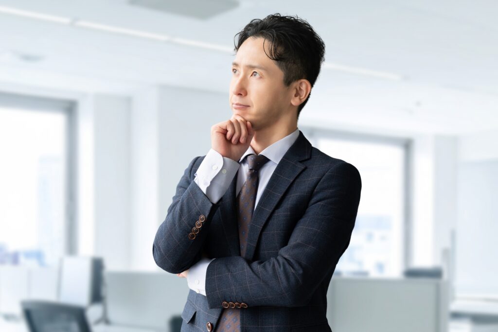 あごに手を当て、考える男性