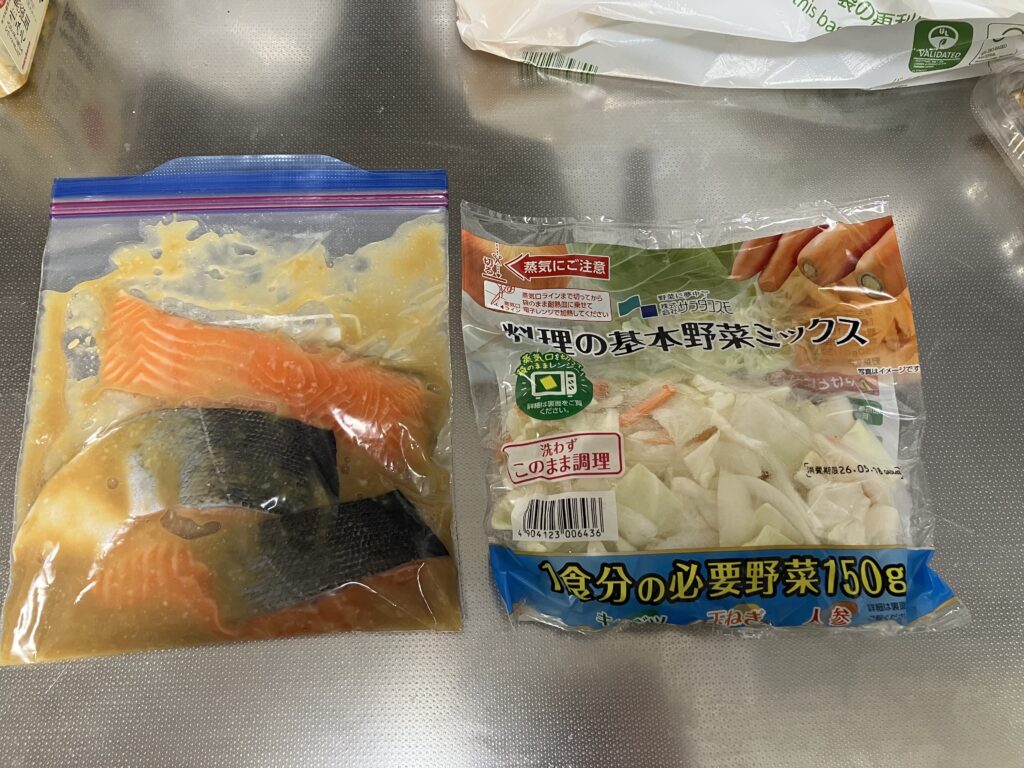味噌だれに漬け込んだ鮭の切り身が入った保存袋と、市販のカット野菜ミックスの袋。
